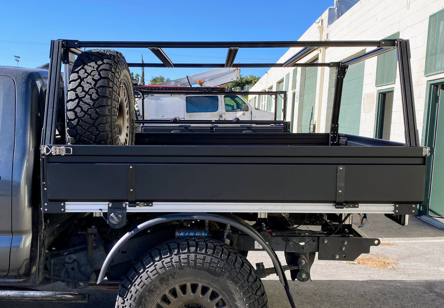 A flatbed with full rack, sheet metal doors, and custom bumper and fender.
